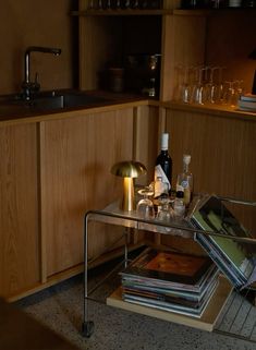 there is a wine glass on the table next to some books and magazines in the kitchen