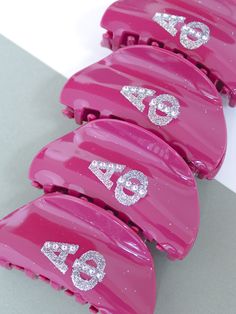 five pink hair clips with glittered numbers on them sitting next to eachother