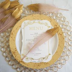 a plate with a menu and some feathers on it