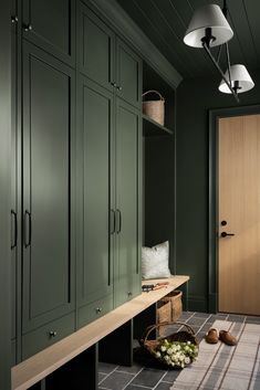 a room with green cupboards and a basket on the floor in front of it