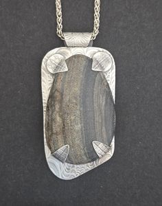 This piece began with a river rock from Big Creek, N.C. which was then hand-shaped and polished. The backplate,bail and tabs were hand-sculpted in fine silver metal clay and fired. The tabs and bail were torch fired to the backplate, which was polished, patina was added and it was polished again. Then the stone was hand-set. It measures 1 1/4" Wide by 2 5/8" Long by 1/2" Deep and comes on a 20" Sterling Silver Wheat Chain. Metal Clay Designs, Jewelry Metalsmithing, Metal Clay Art, Metal Jewelry Handmade, Metal Clay Tutorial, Kinetic Jewelry, Etched Jewelry, Pmc Jewelry, Texture Jewelry