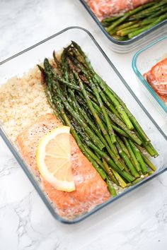 asparagus, salmon and rice in glass dishes on a marble counter top with lemon wedges