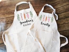 two personalized aprons sitting next to each other on a wooden table with the words grandma's kitchen