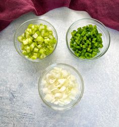 three glass bowls filled with chopped green vegetables