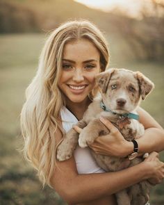 a woman holding a puppy in her arms