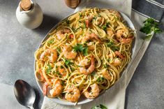 a plate of pasta with shrimp and parsley