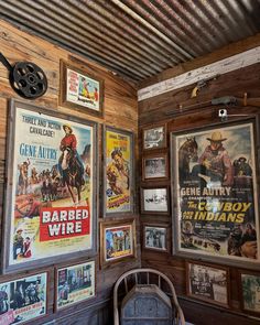 an old western movie poster on the wall next to a chair in a room with wooden paneling