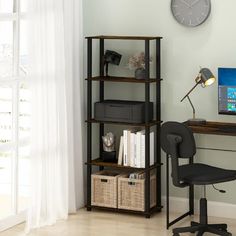 a desk with a computer, chair and clock on the wall in front of it