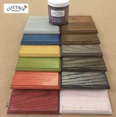 several different colors of wood with a jar of paint next to it