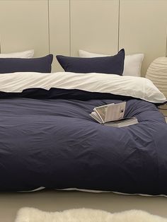 a bed with blue sheets and white pillows