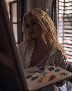 a woman is looking at herself in the mirror with buttons on her shirt and pants