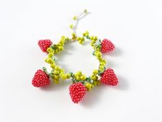 a beaded bracelet with strawberries and green beads