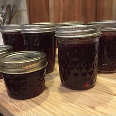 several jars of jam sit on a table