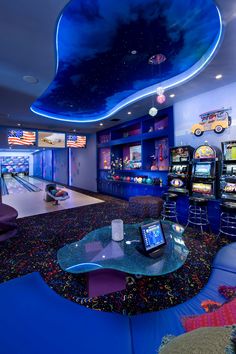 this is a bowling alley with arcade machines in the background and blue lighting on the ceiling