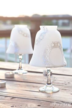 two white lamps sitting on top of a wooden table