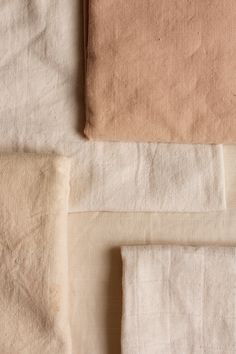 four different colors of linens laid out on top of each other, including beige and white