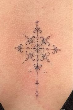 a woman's back with a small tattoo design on the side of her stomach