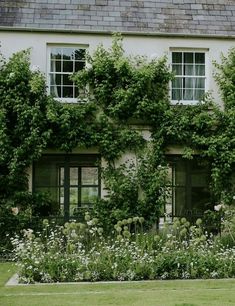 an old house covered in vines and flowers