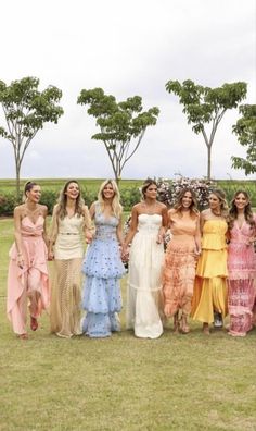 a group of women standing next to each other in dresses