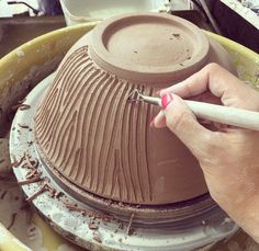 a person is making a vase out of clay with a white crayon pen