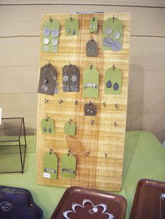 a wooden board with earrings hanging from it's sides next to two suitcases