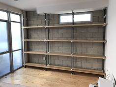 an empty room with wooden shelves and sliding glass doors