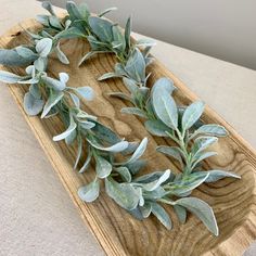 a wooden tray with some green leaves on it