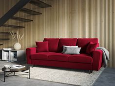 a red couch sitting in front of a stair case