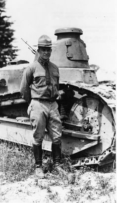 an old photo of a man standing next to a tank