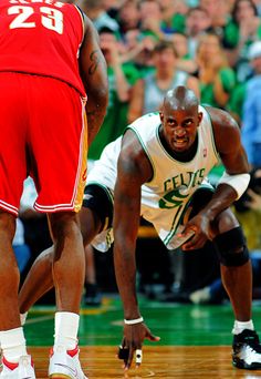 two basketball players on the court during a game with fans in the stands behind them