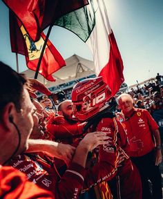 the driver is congratulated by his team mates