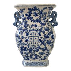 a blue and white vase with an ornate design on the front, sitting against a white background