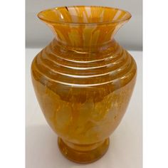 a yellow glass vase sitting on top of a white table