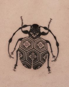 a close up of a bug on a white surface with black and grey designs in the middle