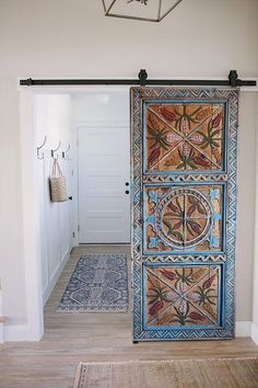 an open door in a hallway leading to a bathroom with a rug on the floor