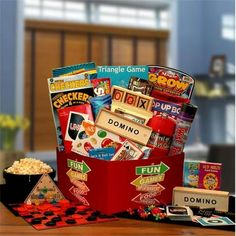 a red box filled with lots of different games and snacks on top of a wooden table