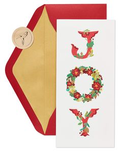 a card with the word joy on it and a christmas wreath in front of it