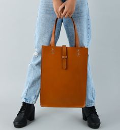 Embrace pure elegance with our artisan-crafted shopper tote. Woven from the very soul of buffalo leather, it doesn't just carry your belongings, but your style and confidence too. Its timeless brown shade, a silent nod to tradition, blends seamlessly with its contemporary design. Grasping the handles feels like shaking hands with timeless luxury. Revel in life's small moments of grandeur with every step, showcasing the world that you have an impeccable taste for both fashion and life's pleasures Modern Brown Bags In Vegetable Tanned Leather, Modern Brown Vegetable Tanned Leather Bag, Brown Bags For Fall, Brown Smooth Grain Bags For Fall, Brown Smooth Grain Tote Shoulder Bag, Fall Smooth Grain Tote Shoulder Bag, Everyday Brown Satchel In Vegetable Tanned Leather, Brown Vegetable Tanned Leather Bag For Everyday, Brown Vegetable Tanned Leather Shoulder Bag With Leather Handles