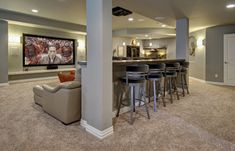 this is an image of a home theater with bar and seating area in the basement