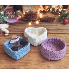 three crocheted baskets sitting on top of a wooden table next to christmas decorations