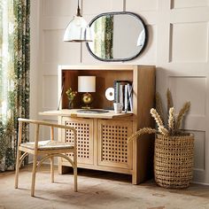 a room with a desk, chair and mirror on the wall next to a potted plant