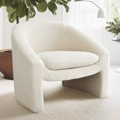 a white chair sitting next to a potted plant