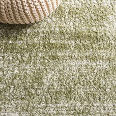 a close up view of a rug with a ball on the floor next to it