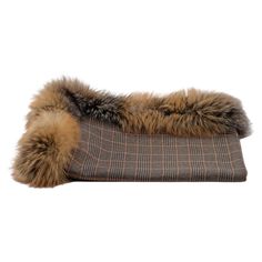 a brown and black plaid pillow with fur on it