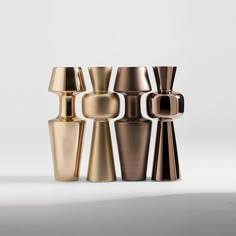 four different types of vases sitting next to each other on a white table top