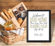 a basket filled with bread and jam next to a sign that says welcome to our home