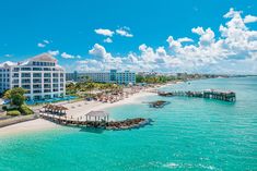 an aerial view of the resort and beach area from across the water, with blue skies in the background