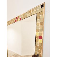 a mirror that is sitting on the ground in front of a wall with a pair of shoes next to it