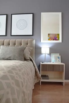 a bedroom with two framed pictures on the wall