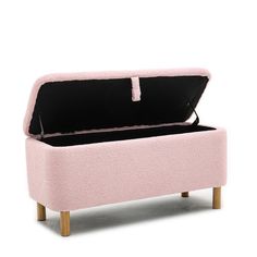 an upholstered pink bench with wooden legs and a black cushion on the top